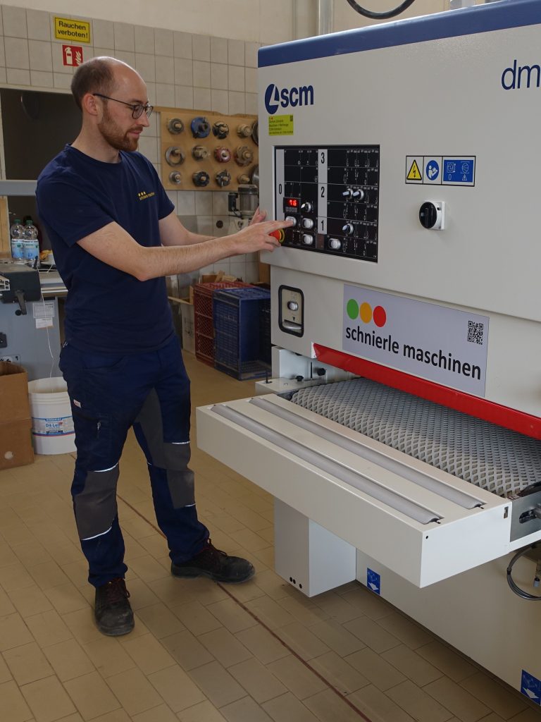 Clemens Schnierle am Bedienfeld einer SCM dmc Breitbandschleifmaschine